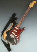 Stratocaster style electric guitar in black finish with red pearloid finger plate, 'well gigged'