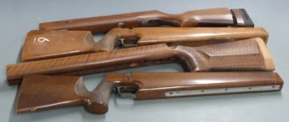 Four wooden target rifle stocks including BSA, two with trigger guards and one with adjustable