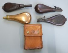 Four shot/powder flasks and a cartridge magazine