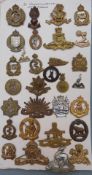 Thirty Commonwealth metal badges including Australian Tank Corps, Royal Australian Regiment, 1st