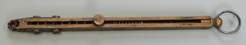 Brass in-line beam sprung percussion cap dispenser with belt loop, 14.5cm long.