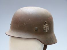 German WW2 steel helmet with eagle decal and stamped d.2 to inner rim, with liner and strap