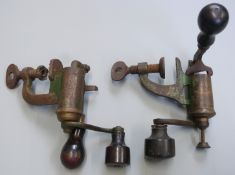 Two 12 bore shotgun cartridge re-loading rollover tools, both with turned wooden handles.
