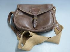 Vintage leather shotgun cartridge bag with canvas shoulder strap.