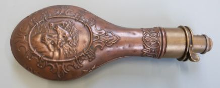Copper and brass powder flask with embossed decoration of horses to both sides, 21cm long