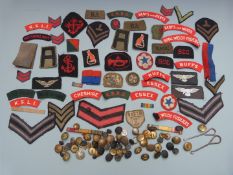 Collection of military cloth shoulder titles including Essex Regiment, Cheshire Regiment, rank and