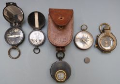 Seven military style compasses including one with a leather case marked SHD and a NEAG Berlin SO