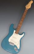 Stratocaster style electric guitar in teal blue glitter lacquer finish with white finger plate