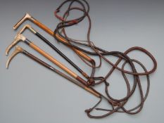 Four riding whips with horn handles, two with hallmarked silver mounts