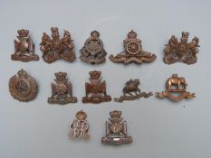 Twelve British Army badges including The West Riding Regiment, Wiltshire Regiment etc