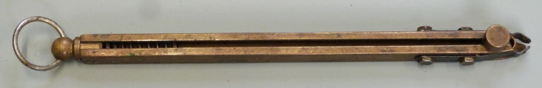 Brass in-line beam sprung percussion cap dispenser with belt loop, 14.5cm long.