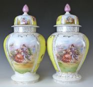 A pair of German porcelain covered pedestal baluster vases with alternate Watteau and flower