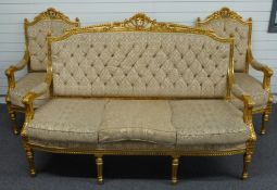 An upholstered continental style giltwood sofa and two chairs raised on reeded, turned and stepped