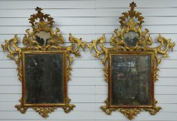 A pair of 18thC Italian Rococo giltwood framed mirrors with silvered glass and arching finials, W100