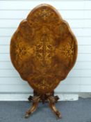A shaped quarter walnut veneered marquetry tilt top table with crossbanded and string inlay