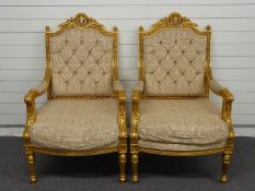 A pair of upholstered continental style giltwood chairs raised on reeded turned and stepped legs,