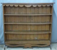 An oak bookcase with shaped apron and base, W144 x D26 x H137cm