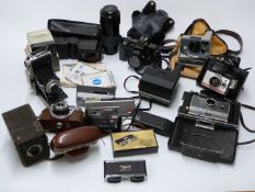 A collection of cameras and accessories including several Polaroid, Minolta 7000 with 50mm lens,