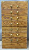 A small oak campaign style collector's chest of seven drawers with brass handles and fittings, W39 x
