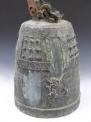 A substantial Archaic Chinese bronze bell with incised and stud work decoration and a dragon finial,