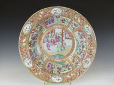 A large Canton Chinese famille rose bowl decorated with multiple court scenes and a floral border