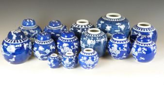 Thirteen Chinese ginger jars, some with covers and most decorated with prunus blossom on a blue