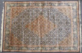 Persian carpet / rug with central lozenge decoration on navy ground and knotted fringe, 280 x 183cm