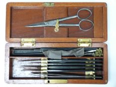 A 19thC travelling surgeon's set in mahogany case, length 19cm, together with a fleam or similar