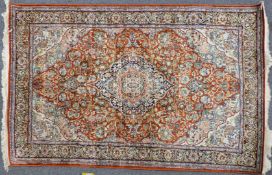 Persian carpet / rug with central lozenge decoration on a red ground and knotted fringe, 195 x