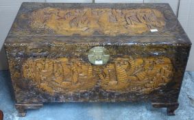 Chinese heavily carved camphor wood trunk with engraved brass lock raised on carved bracket feet,