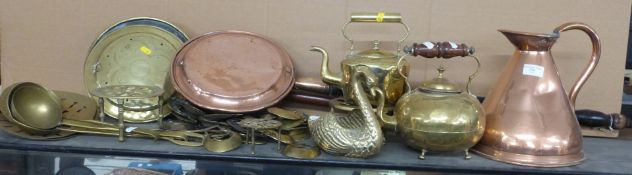 A collection of brass and copper ware including a measuring jug, kettles, warming pans, horse
