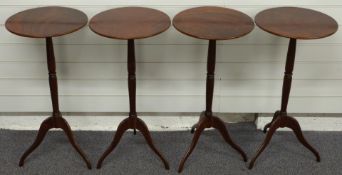 A set of four mahogany circular wine tables with stepped tapering supports, raised on slender