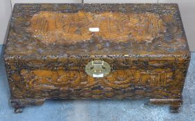 Chinese heavily carved camphor wood trunk with engraved brass lock raised on carved bracket feet,