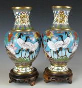 A pair of cloisonné pedestal vases on stands, decorated with storks on a blue ground, H20cm
