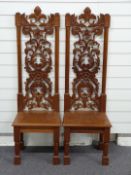 A pair of carved mahogany hall chairs with ash or elm seats and lion decoration, H121cm