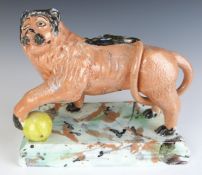 Staffordshire Obadiah Sherratt style pottery figure of a lion with ball, on sponge decorated base,