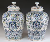 A pair of early 18thC Dutch Delft polychrome decorated covered baluster vases decorated with birds
