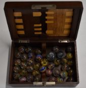 Thirty-eight multi-coloured latticinio and onionskin glass marbles, largest 23mm in diameter, in a