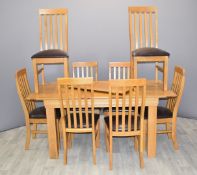 Contemporary light oak extendable table and eight upholstered chairs, W133 (extended 204) x D91 x