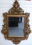 A late 17th/18thC Spanish baroque giltwood mirror with scrolling surround, putti masks and