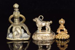 A Victorian fob in the form of a dog, another Victorian fob and a brass fob