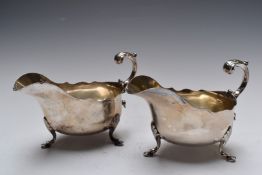 Pair of Victorian hallmarked silver sauce or gravy boats with S scroll handles, raised on shell