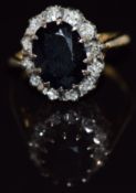 An 18ct gold ring set with an oval cut sapphire surrounded by diamonds, 5.5g, size L/M
