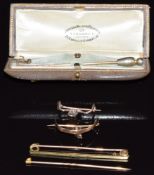 An 18ct gold brooch (2.7g), two 9ct gold brooch mounts (2.1g), and a section of stick pins