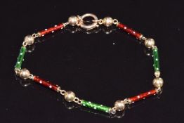 A 9ct c1900 bracelet made up of barrel and sphere links set with green and red enamel, 6.7g