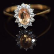 An 18ct gold ring set with an oval cut yellow sapphire of approximately 0.75ct surrounded by
