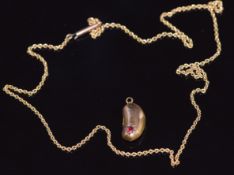 A 9ct gold necklace and an Edwardian 9ct gold kidney bean shaped charm set with a ruby, 3.4g