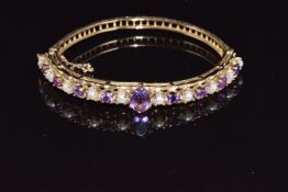 A 9ct gold bangle set with alternating amethysts and pearls, 16g