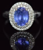 A 14k gold ring set with an oval cut tanzanite surrounded by two rows of diamonds, 4.5g, size Q