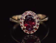 A 9ct gold ring set with garnets in an oval cluster, 2.4g, size K